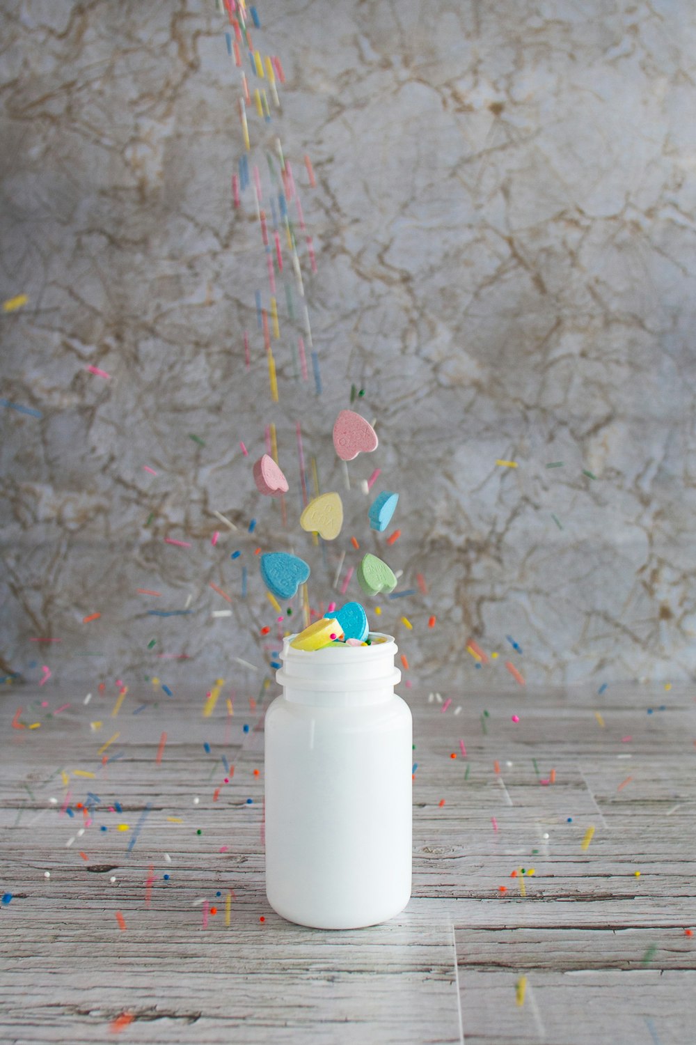 white plastic bottle on white and red floral textile