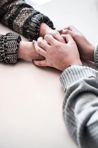 person in gray long sleeve shirt holding persons hand