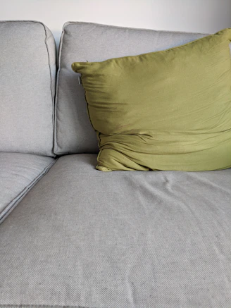 A comfortable hugging pillow placed on a modern sofa in a bright living room.
