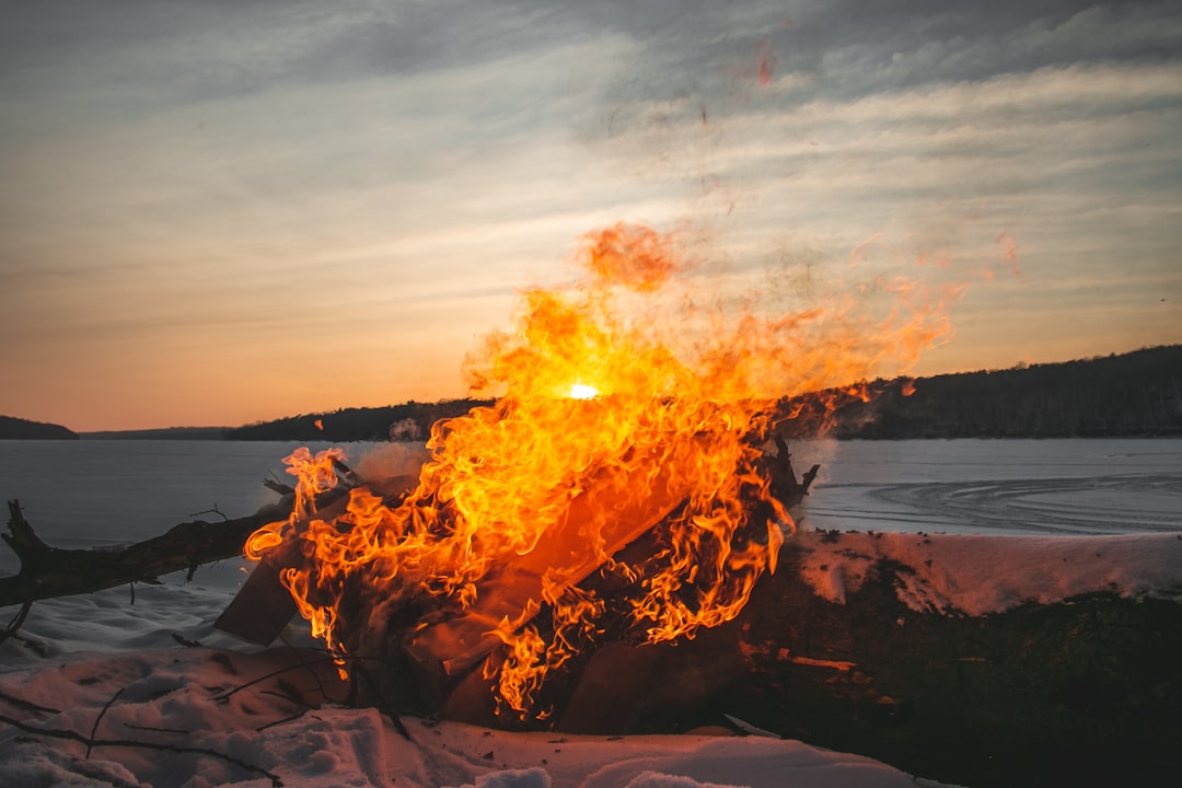 a fire burning in the middle of a snow covered field