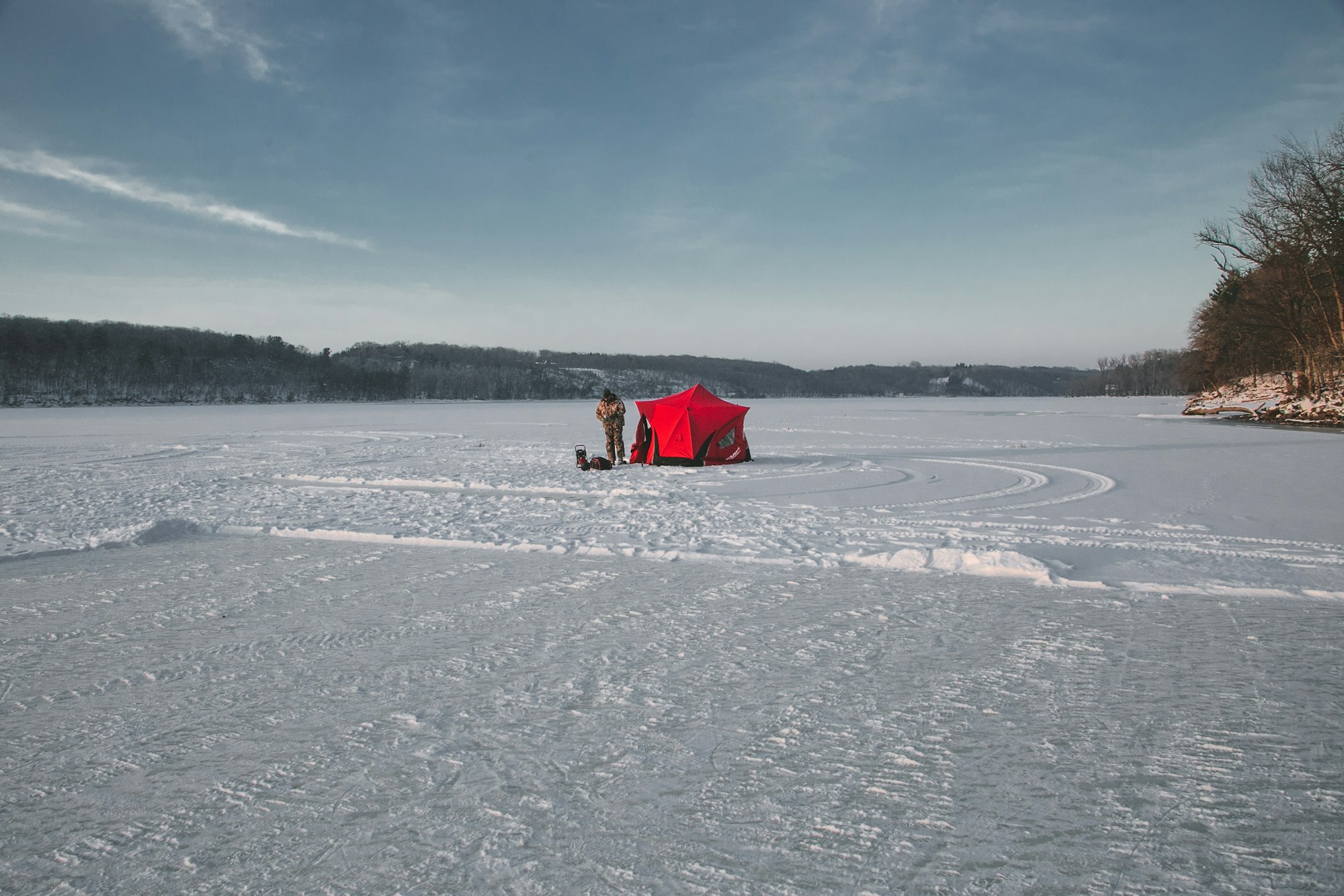 an ice fisherman near his portable shelter