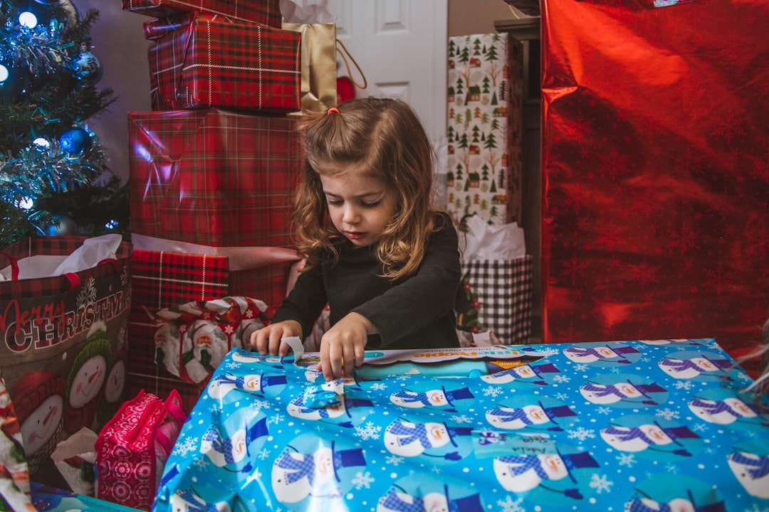 girl in black jacket sitting on blue and white table