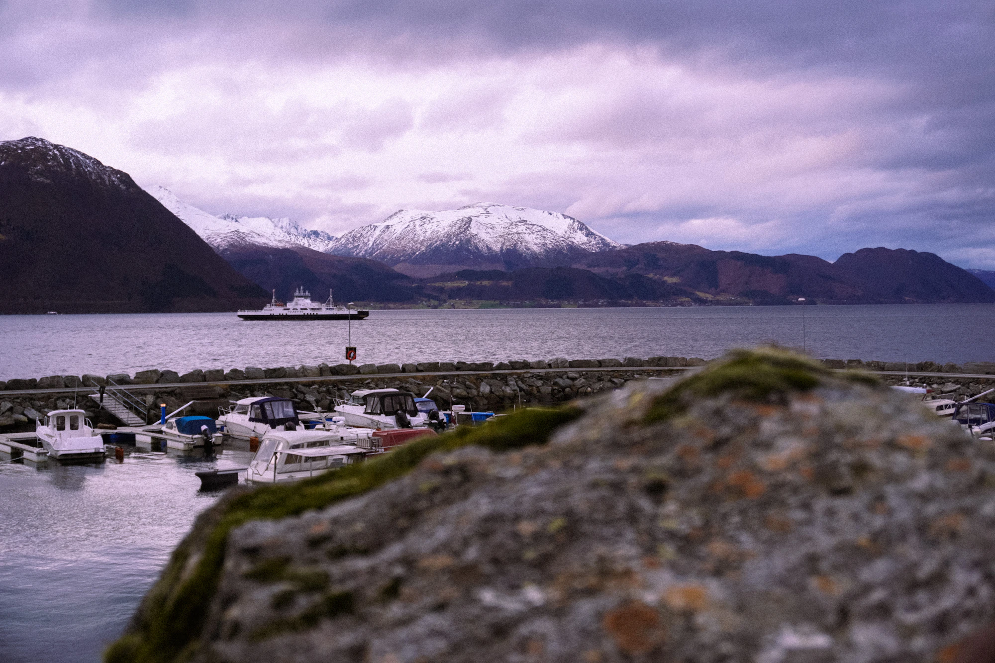 A small harbour below snowy mountains