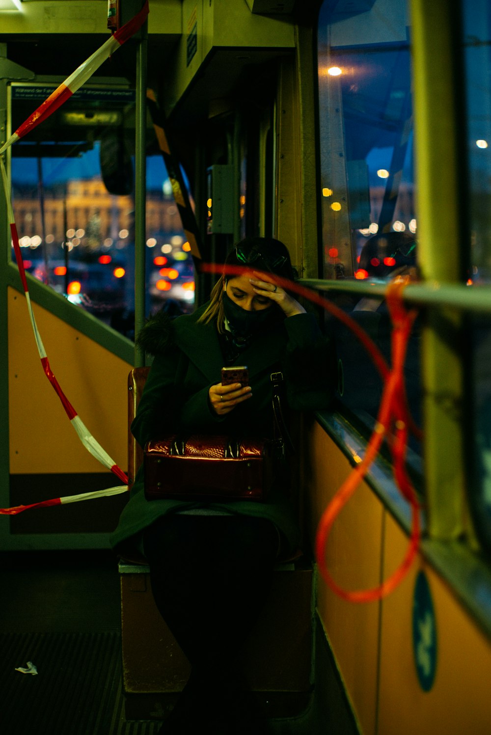 Mujer en chaqueta negra y pantalones negros sentada en el tren