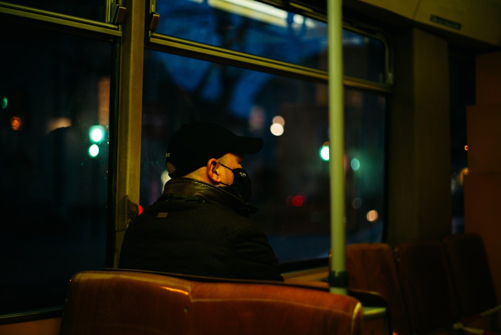 man in black shirt sitting on brown chair