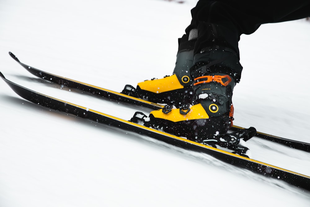 person in black jacket and black pants riding on snowboard during daytime