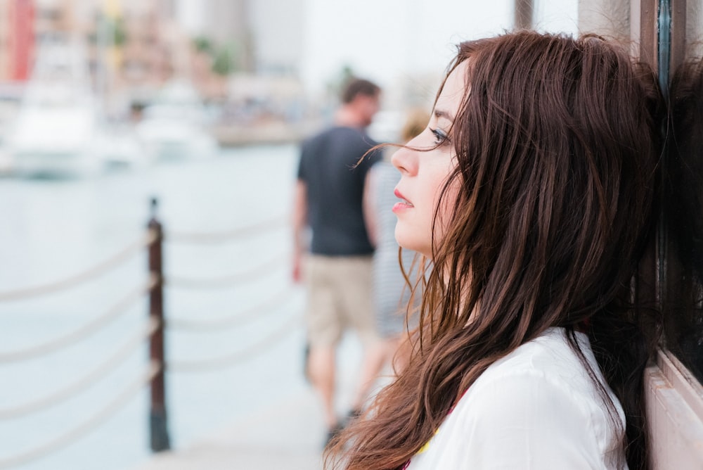 woman in white shirt standing near body of water during daytime