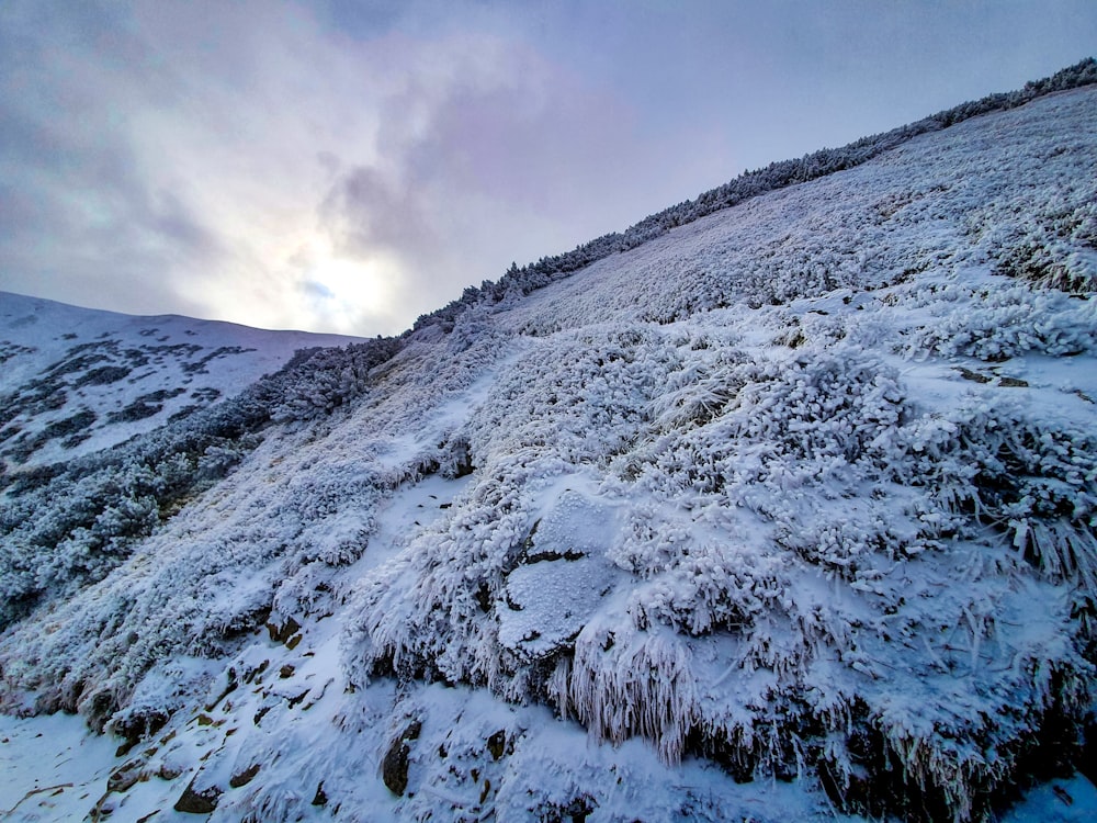 snow covered mountain under cloudy sky during daytime