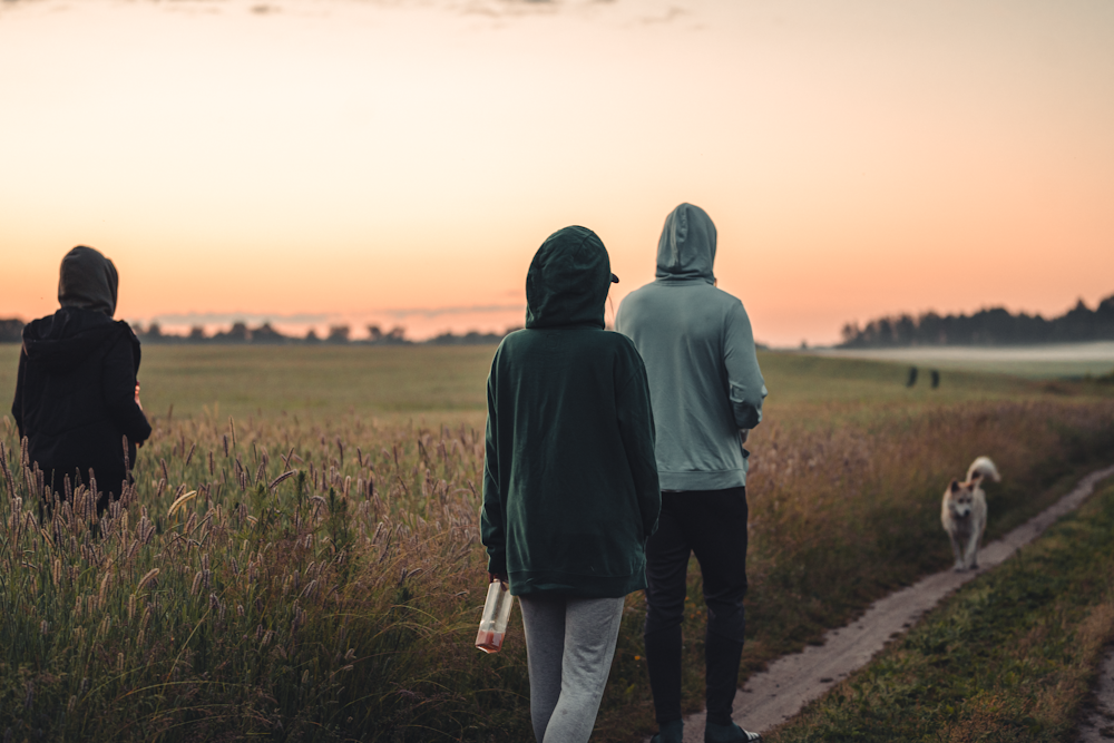 man in black hoodie standing on pathway during daytime