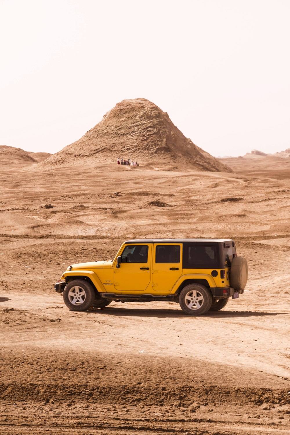 yellow suv on brown sand