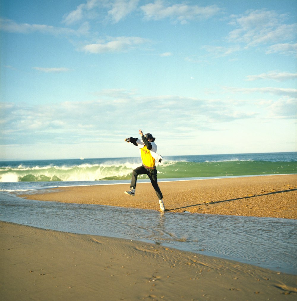 woman in black jacket and yellow skirt standing on seashore during daytime