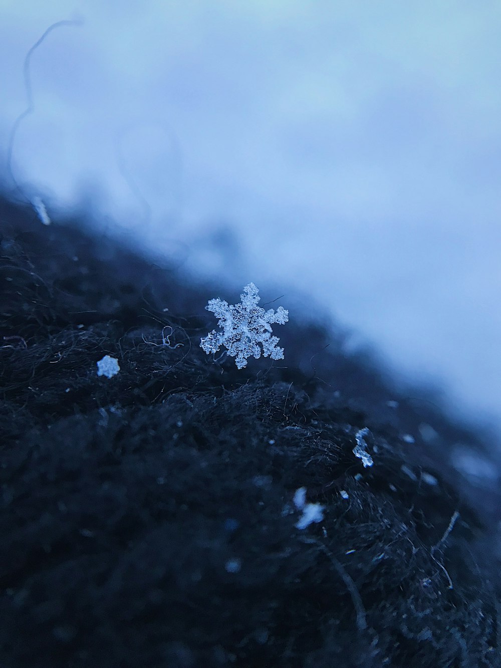 weiße Schneeflocken auf schwarzem Textil