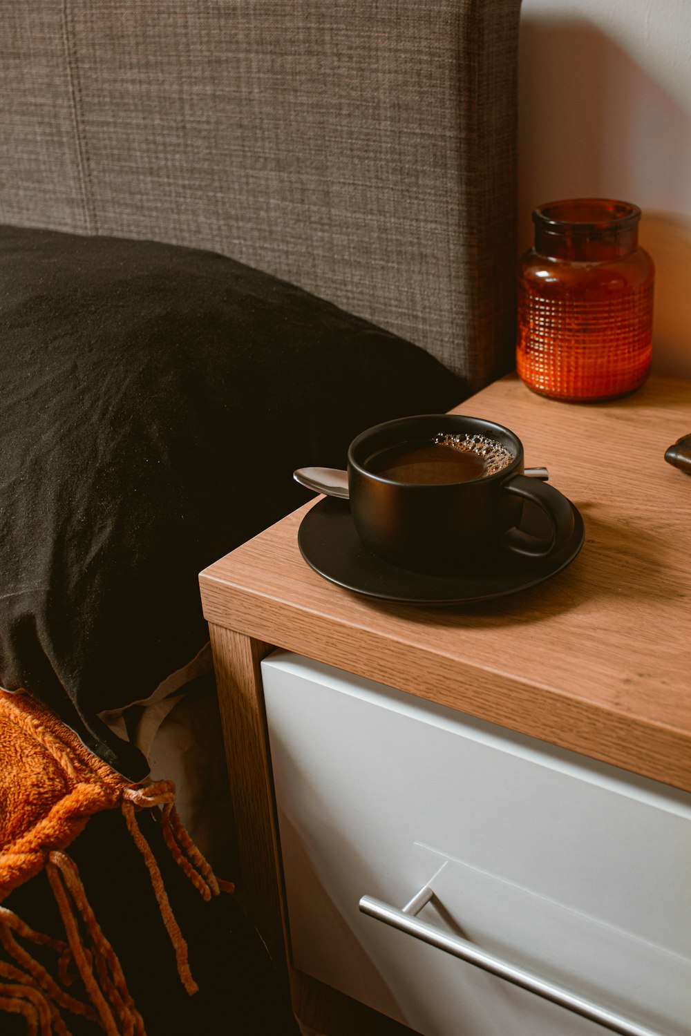 Taza de cerámica negra sobre mesa de madera marrón