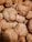 A close-up view of a pile of freshly baked cookies with a golden-brown, crumbly texture. The cookies are stacked on top of each other, showing their rough, homemade appearance.