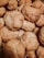 A close-up view of a pile of freshly baked cookies with a golden-brown, crumbly texture. The cookies are stacked on top of each other, showing their rough, homemade appearance.