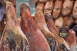 Close-up of cured jamón hanging in a traditional cellar.
