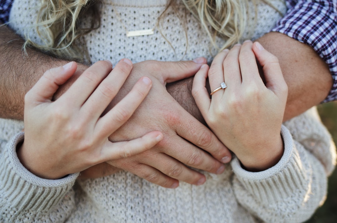 woman in white knit sweater wearing gold ring