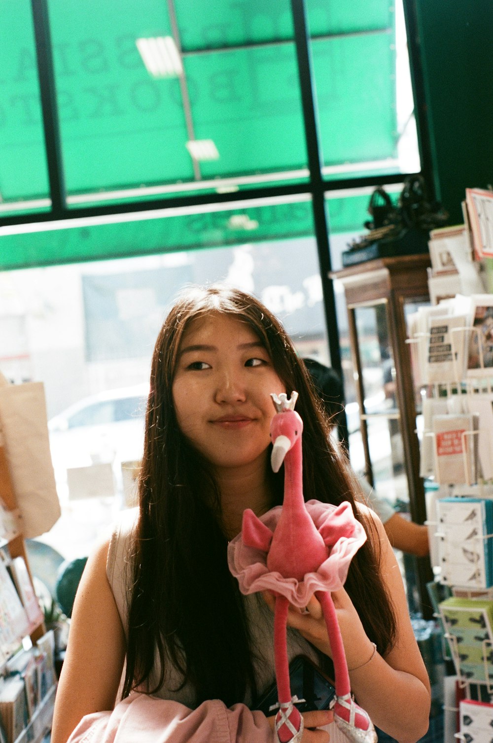 woman in white tank top holding pink rose