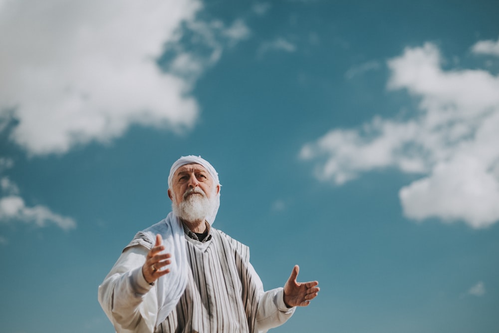 man in white and black striped dress shirt under blue sky during daytime