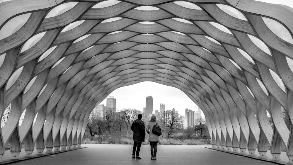 grayscale photo of man and woman standing on pathway