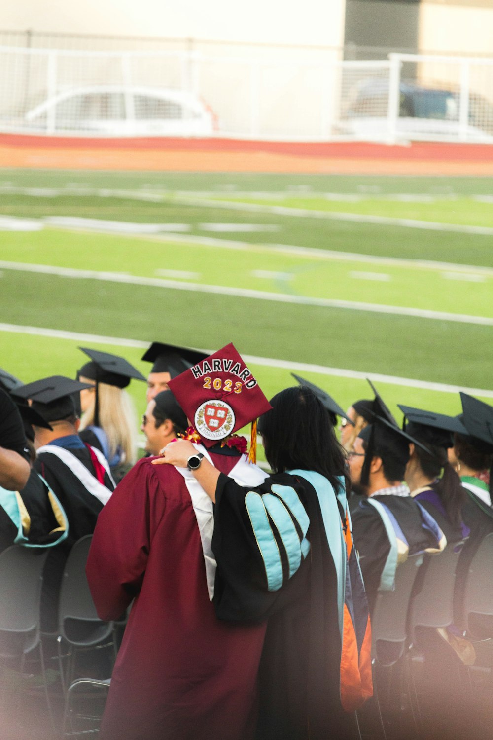 people in red and black academic dress standing on green grass field during daytime