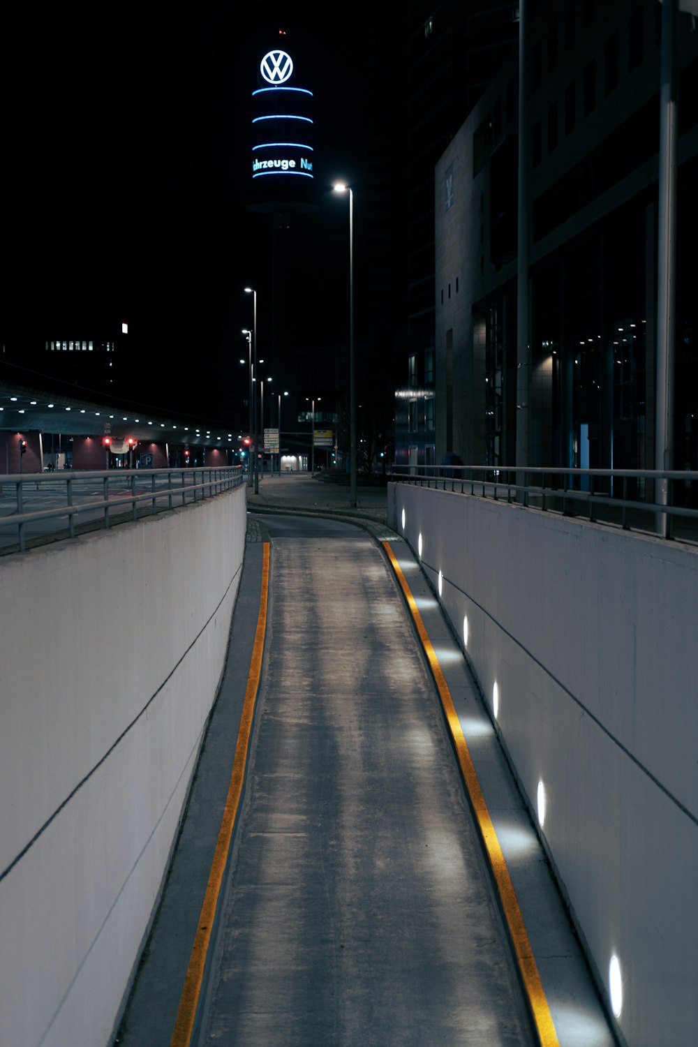 a long empty road with a building in the background