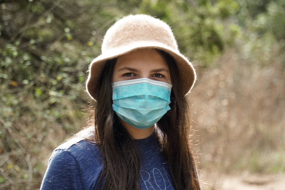 girl in blue crew neck shirt wearing white bucket hat