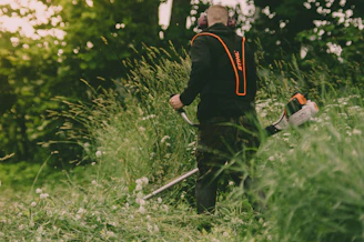 man in black long sleeve shirt holding brown stick