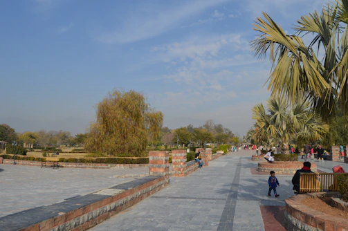 Rhina Valentín walking through a lush city park with diverse visitors enjoying the greenery.
