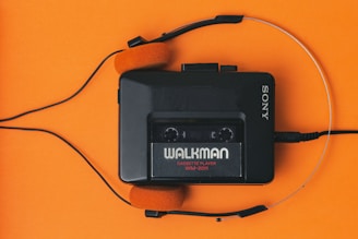 Walkman cassette player with headphones attached to it