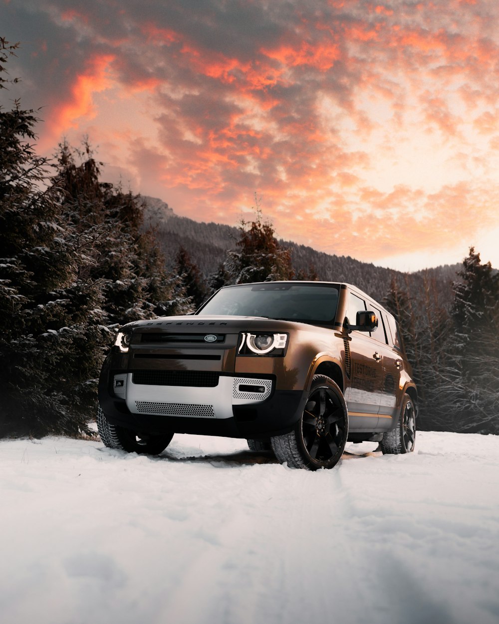 夕暮れ時の雪に覆われた地面に白いSUV