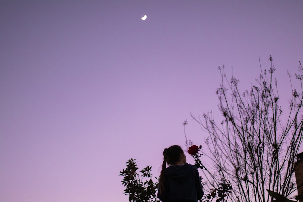 woman in black jacket standing under full moon