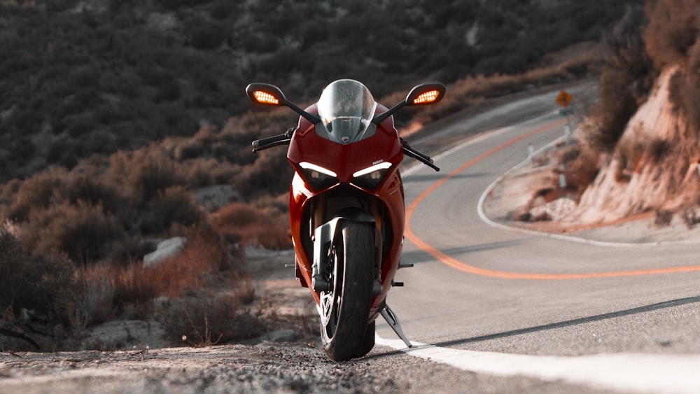 red and black sports bike on road during daytime