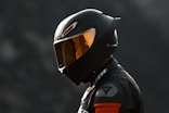 black and orange helmet on black motorcycle