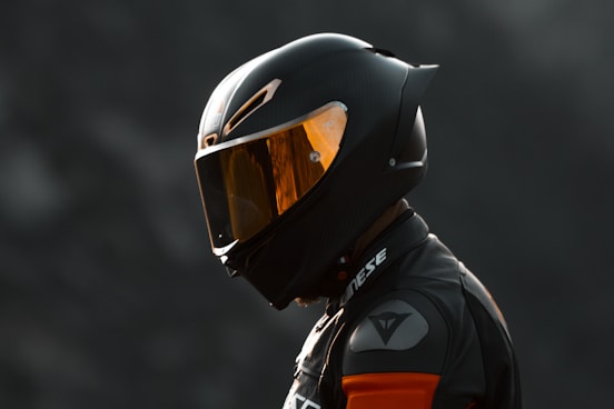black and orange helmet on black motorcycle