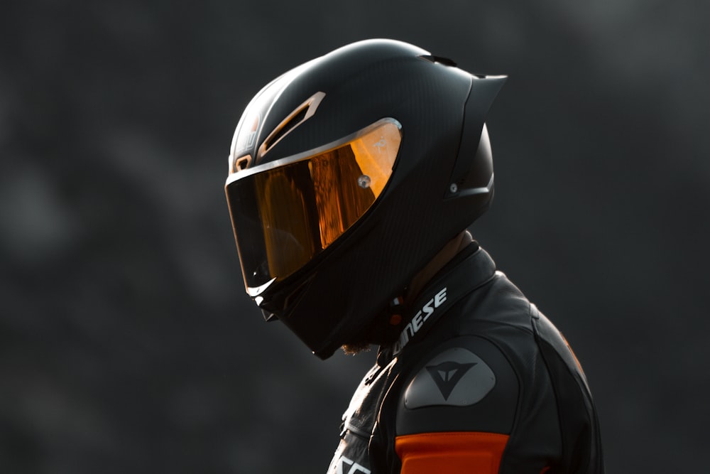 黒のオートバイに黒とオレンジのヘルメット