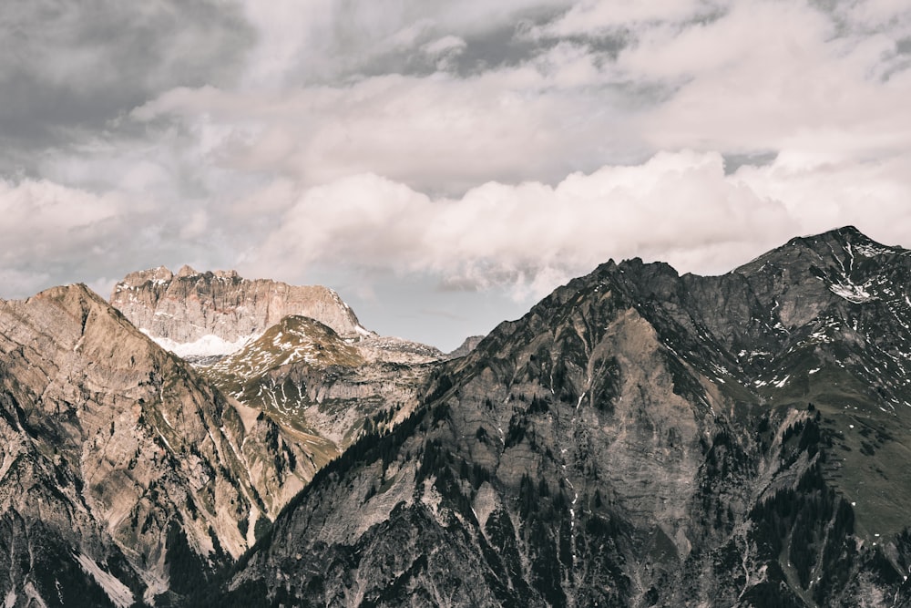 brown and white rocky mountain under white clouds during daytime