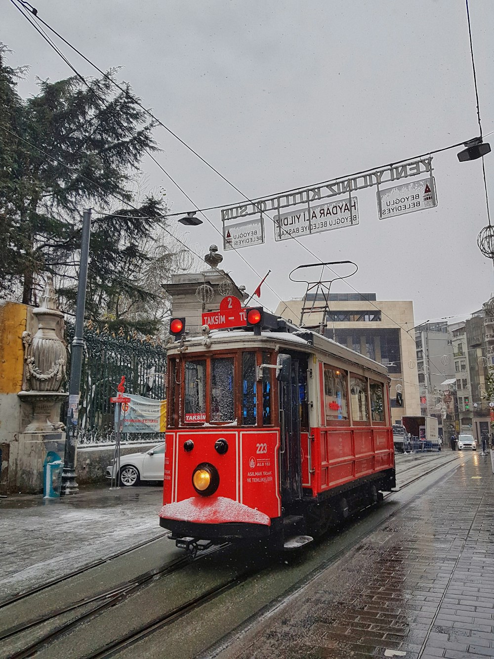 Rote Straßenbahn tagsüber auf der Straße in der Nähe von Gebäuden