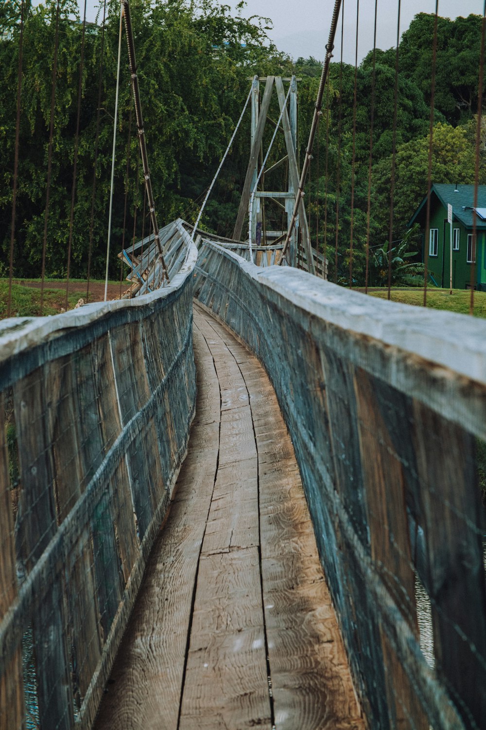 brown wooden bridge over green grass field