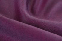 Close-up of soft fabric textures in shades of purple and lilac, highlighting quality materials.
