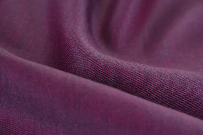 Close-up shot of rich purple and gold fabric swatches showcasing fine texture.