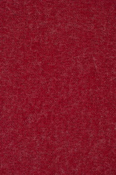 Close-up of burgundy fabric with fine stitching highlighting texture.