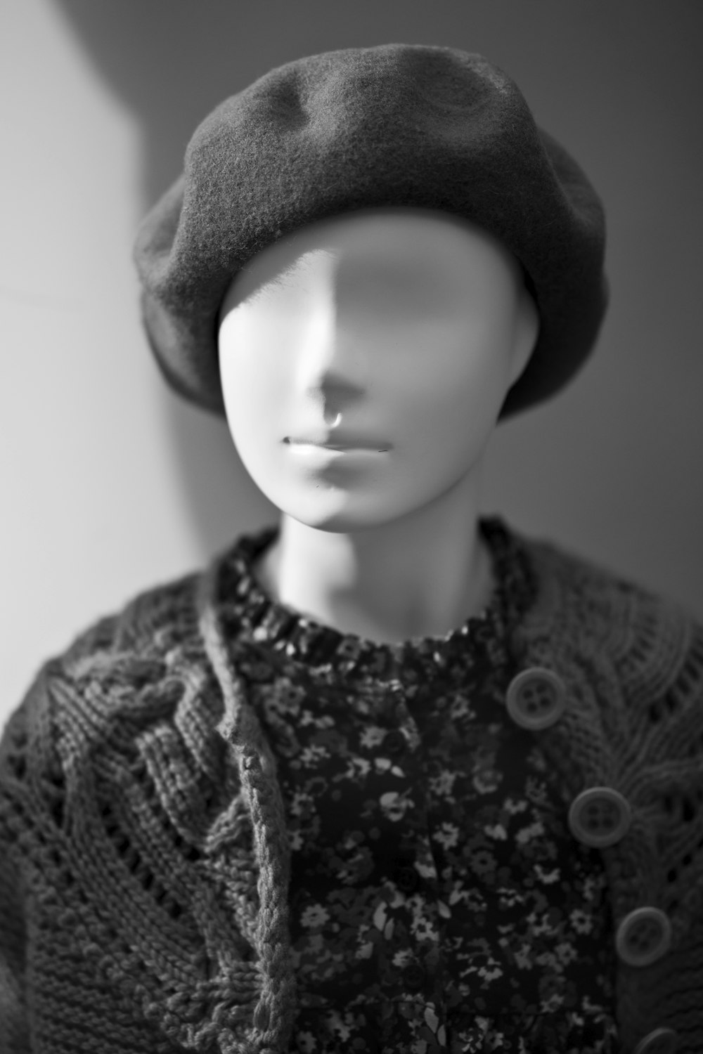 Foto en escala de grises de mujer con gorro de punto y camisa de punto