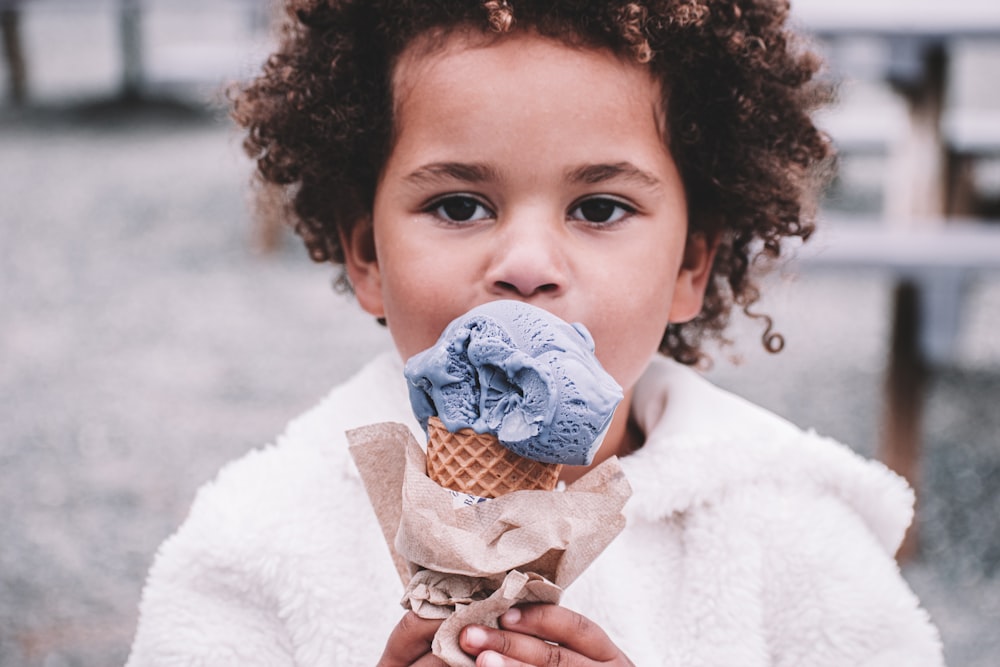 girl in white sweater holding ice cream