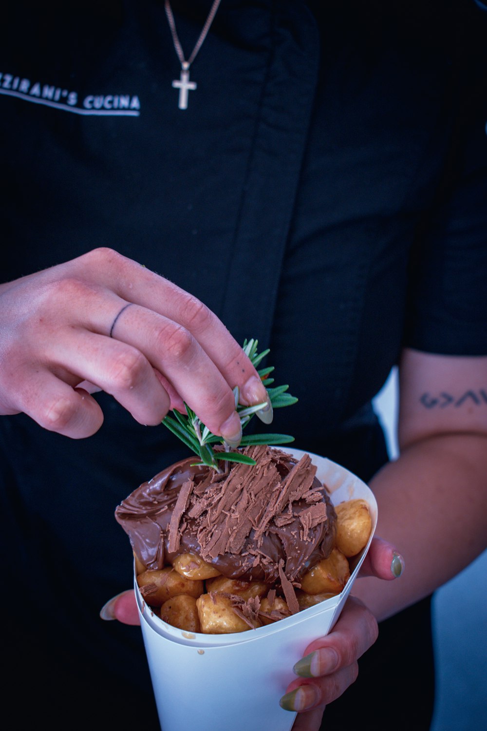 person in black long sleeve shirt holding brown meat