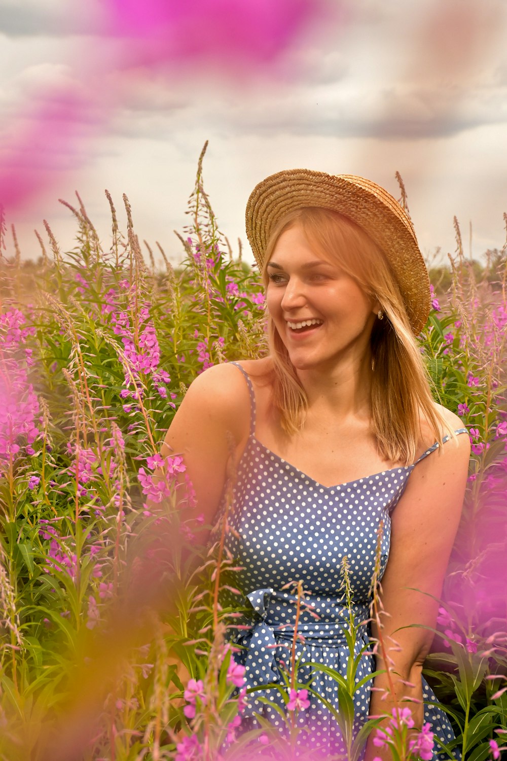 woman in black and white polka dot spaghetti strap top wearing brown straw hat standing on near on near on