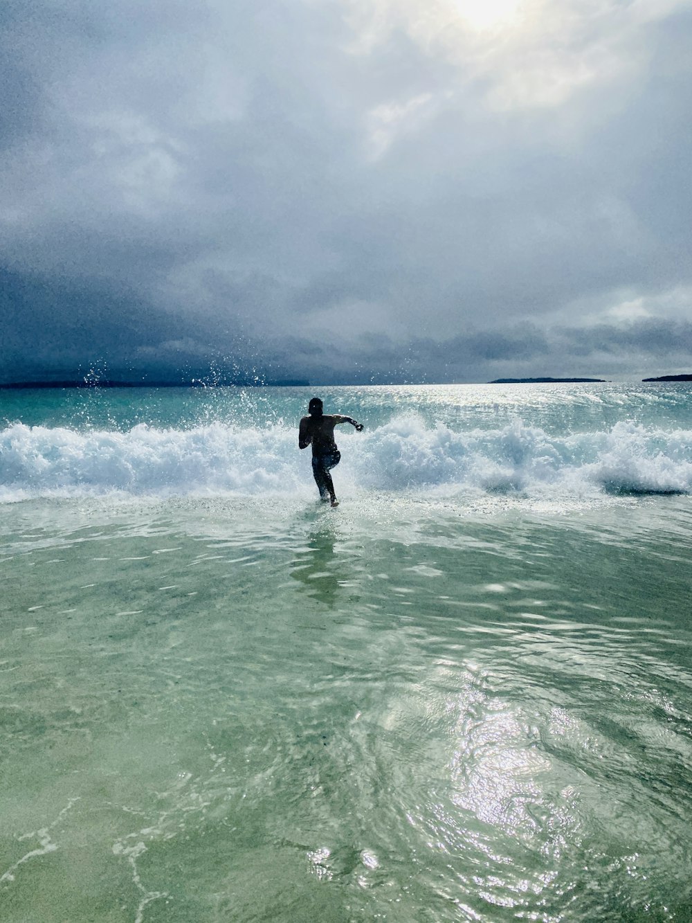 man in black wet suit on water under cloudy sky during daytime