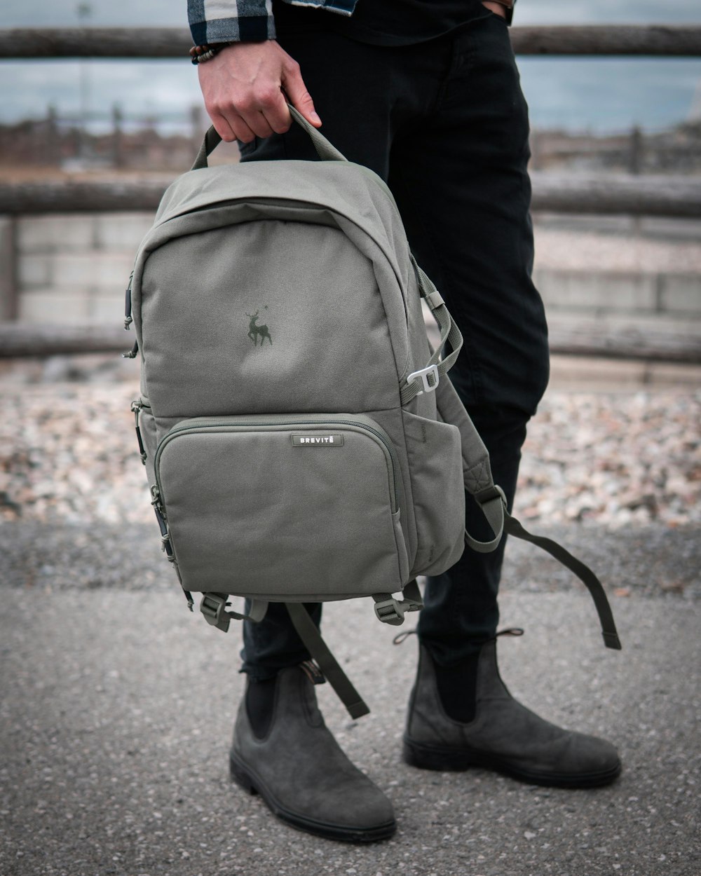 person in black jacket carrying gray backpack