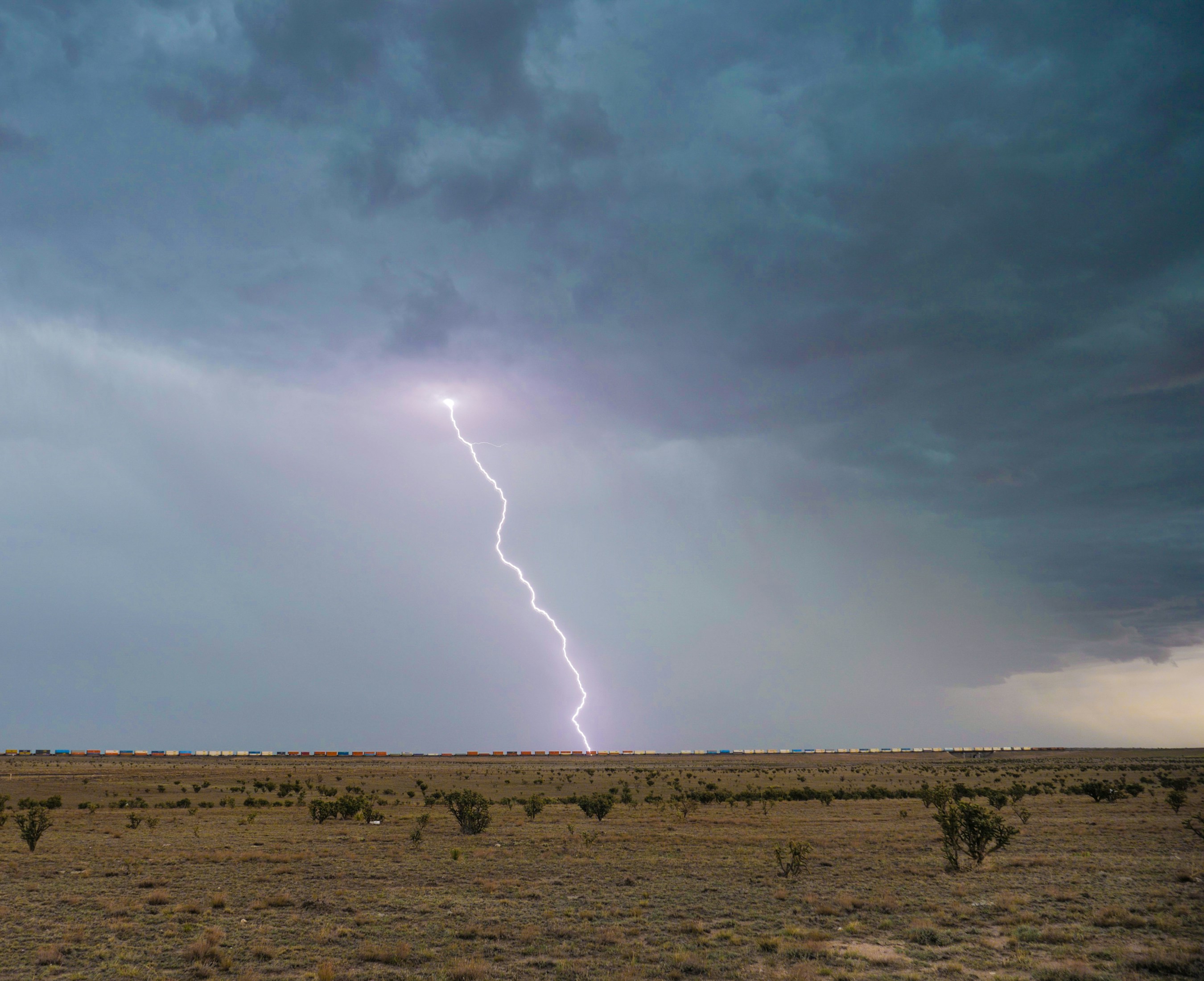 white smoke coming out from brown field, Lightning strike from a monsoon storm near Vaughn, New Mexico.