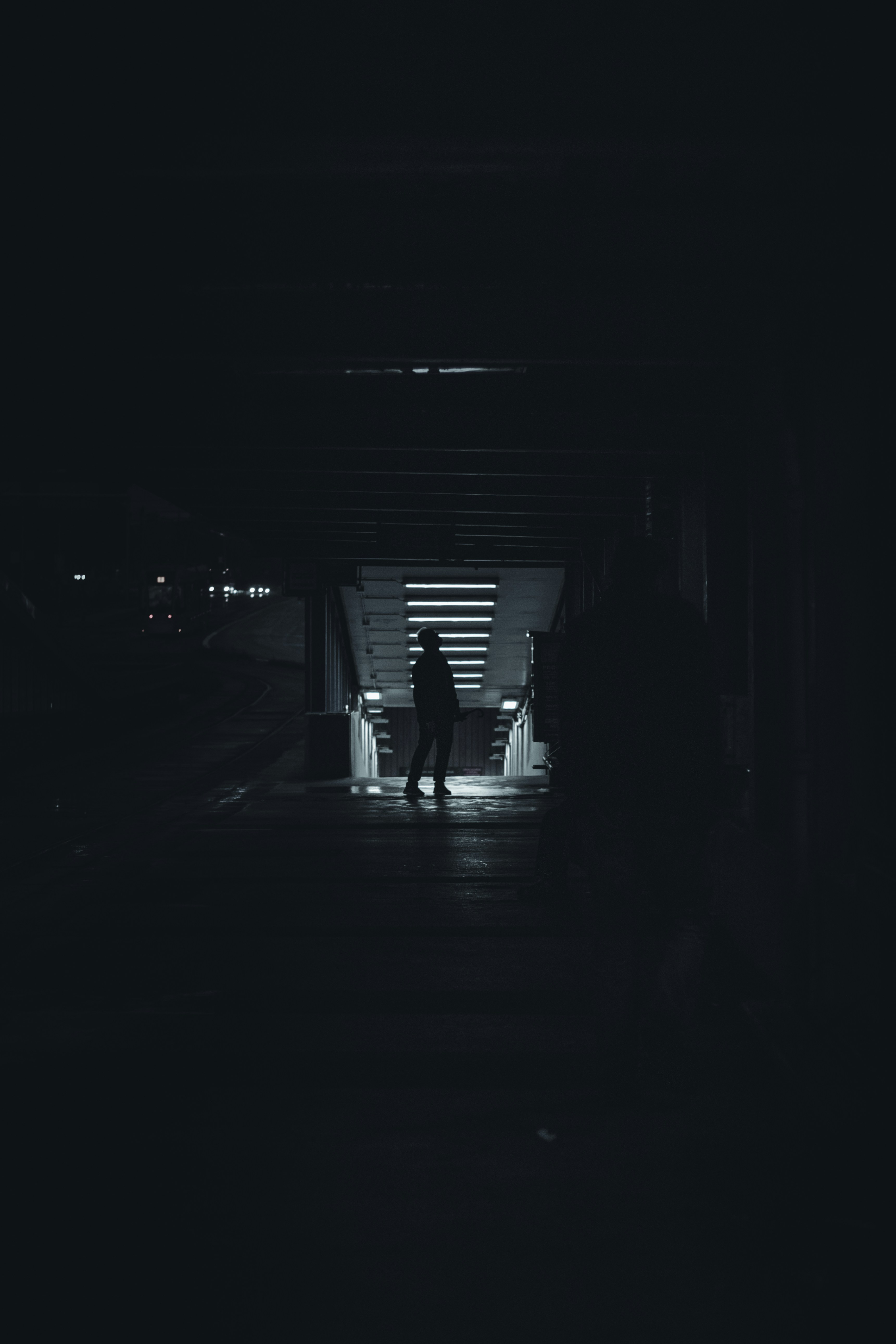 silhouette of person walking on tunnel